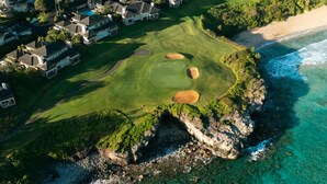 An aerial view of a coastal golf course with clear waters, rocky outcrops, and residential buildings. - Dramatic Ocean Views - Fantastic Location - REDUCED RATES! (Kapalua)