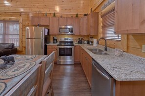 Enjoy cooking in this well-equipped kitchen with a refrigerator, microwave, oven, and dishwasher.
