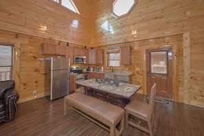 Cozy cabin with a central dining area, kitchenette, and natural light.