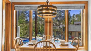 Un coin repas avec une table en bois, quatre chaises et un luminaire suspendu.