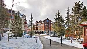 A snow-covered street with a fire lane sign, buildings with balconies, and a ski lodge. - River Run Condo, 200 yards to gondola, Slope Views, Heated Garage, Free WiFi (Keystone)