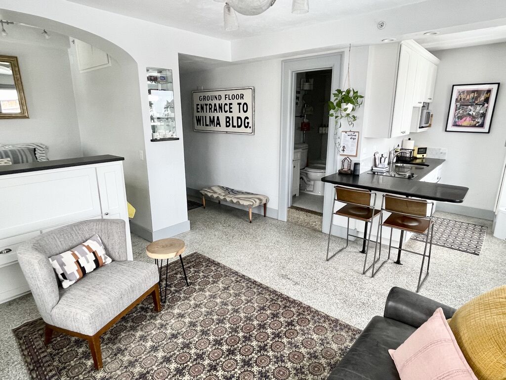 Ein modernes Wohnzimmer mit einer Couch, einem Sessel und einem Essbereich mit Tisch und Stühlen.
