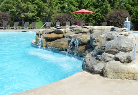Una piscina al aire libre de temporada, sombrillas
