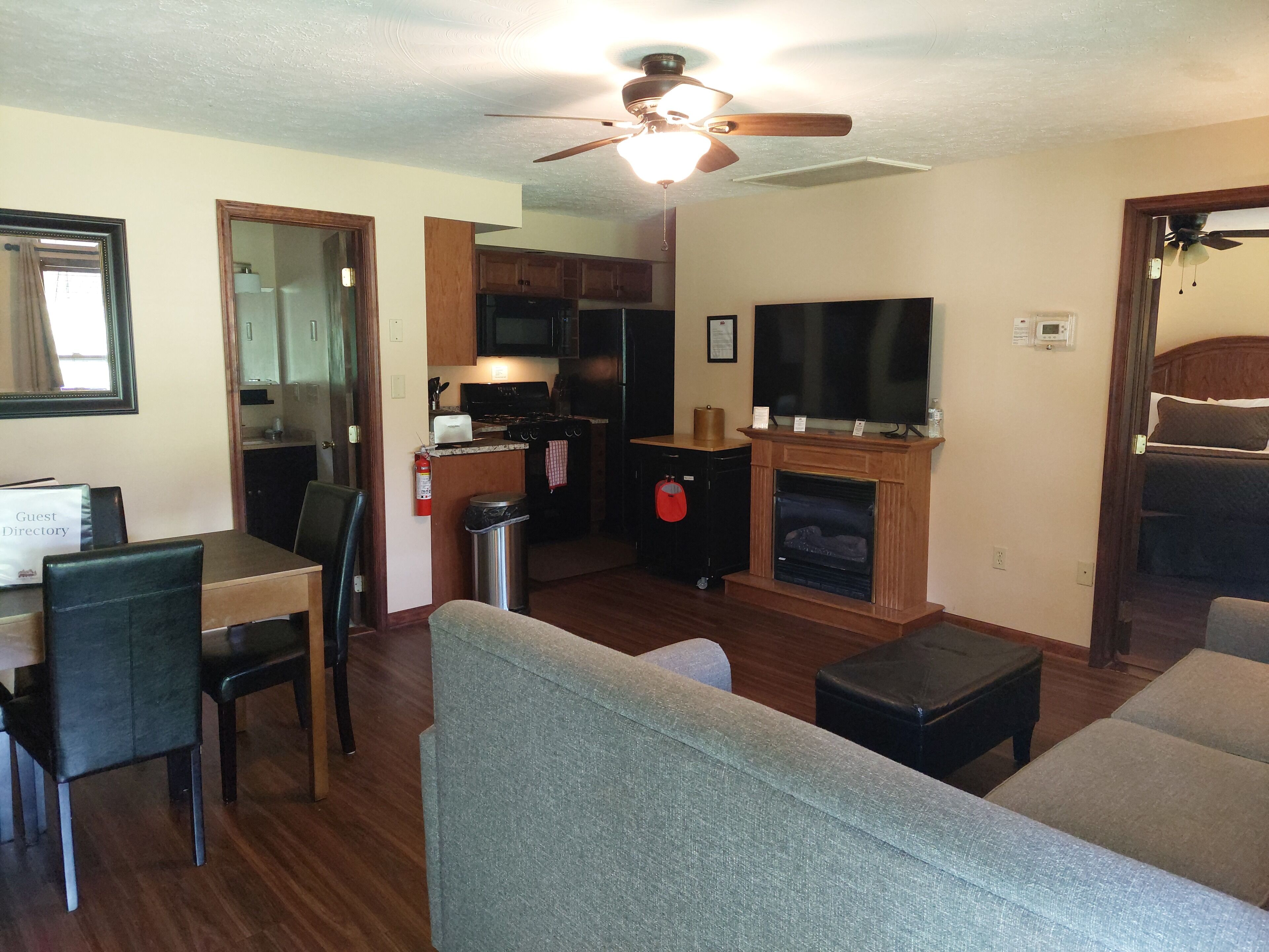A compact living space with a dining area, kitchenette, and a fireplace.