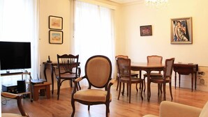 A living room with a TV, wooden furniture, and artwork on the walls.