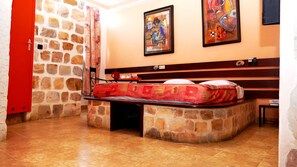 Cozy retreat with a bed, artworks, and a wooden bench.