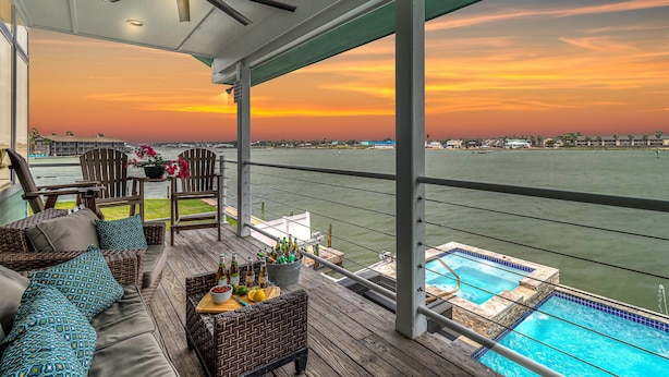 A covered outdoor area with wicker furniture, a small pool, and a view of the water. - Sunsets | Private Pool & Hot Tub | Green Lights | Boat Lift | Icemaker (Rockport)
