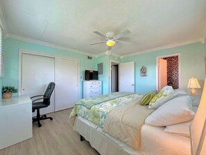 A bedroom with a bed, a desk, a chair, a ceiling fan, and a television. - 231 Dundee Cozy Home Short Walk to Beach (Fort Myers Beach)