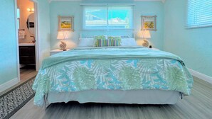 A bedroom with a bed, two bedside lamps, a ceiling fan, and a window with blinds. - 231 Dundee Cozy Home Short Walk to Beach (Fort Myers Beach)