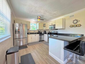 A compact kitchen with stainless steel appliances, a microwave, and a coffee maker. - 231 Dundee Cozy Home Short Walk to Beach (Fort Myers Beach)