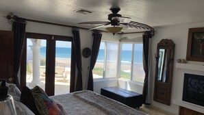 A bedroom with a bed, a ceiling fan, a view of the beach, and a large window. - Beachfront House in Las Concha's.   (Puerto Penasco)