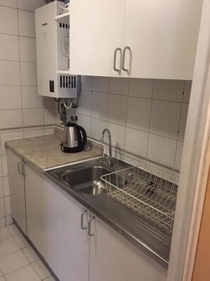 Een magnetron, een oven, een waterkoker, kookgerei, borden en bestek
