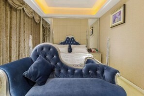 A bedroom with a large bed, a chair, and a nightstand.