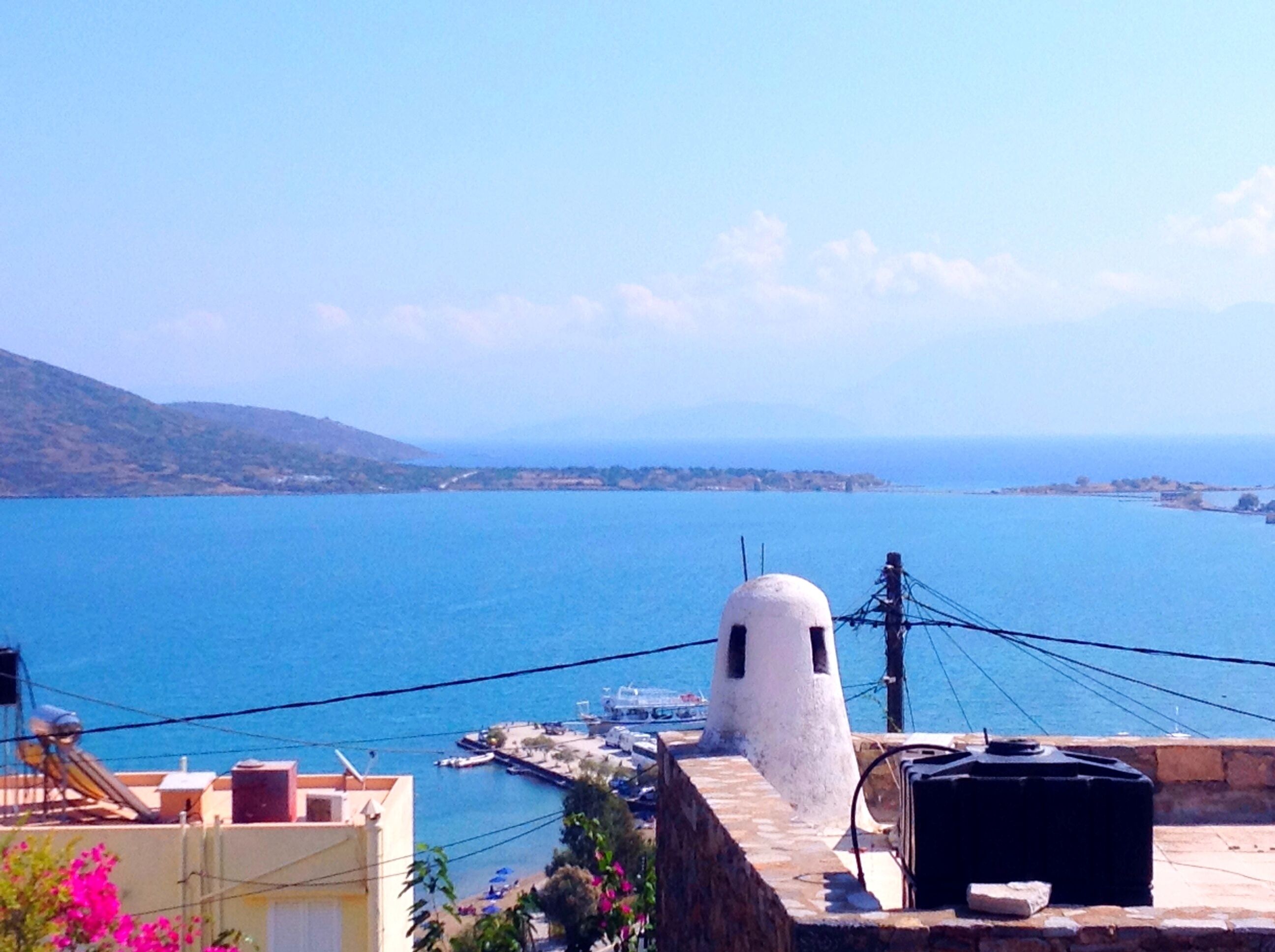 A coastal view with a clear sky, a body of water, and a distant landmass.