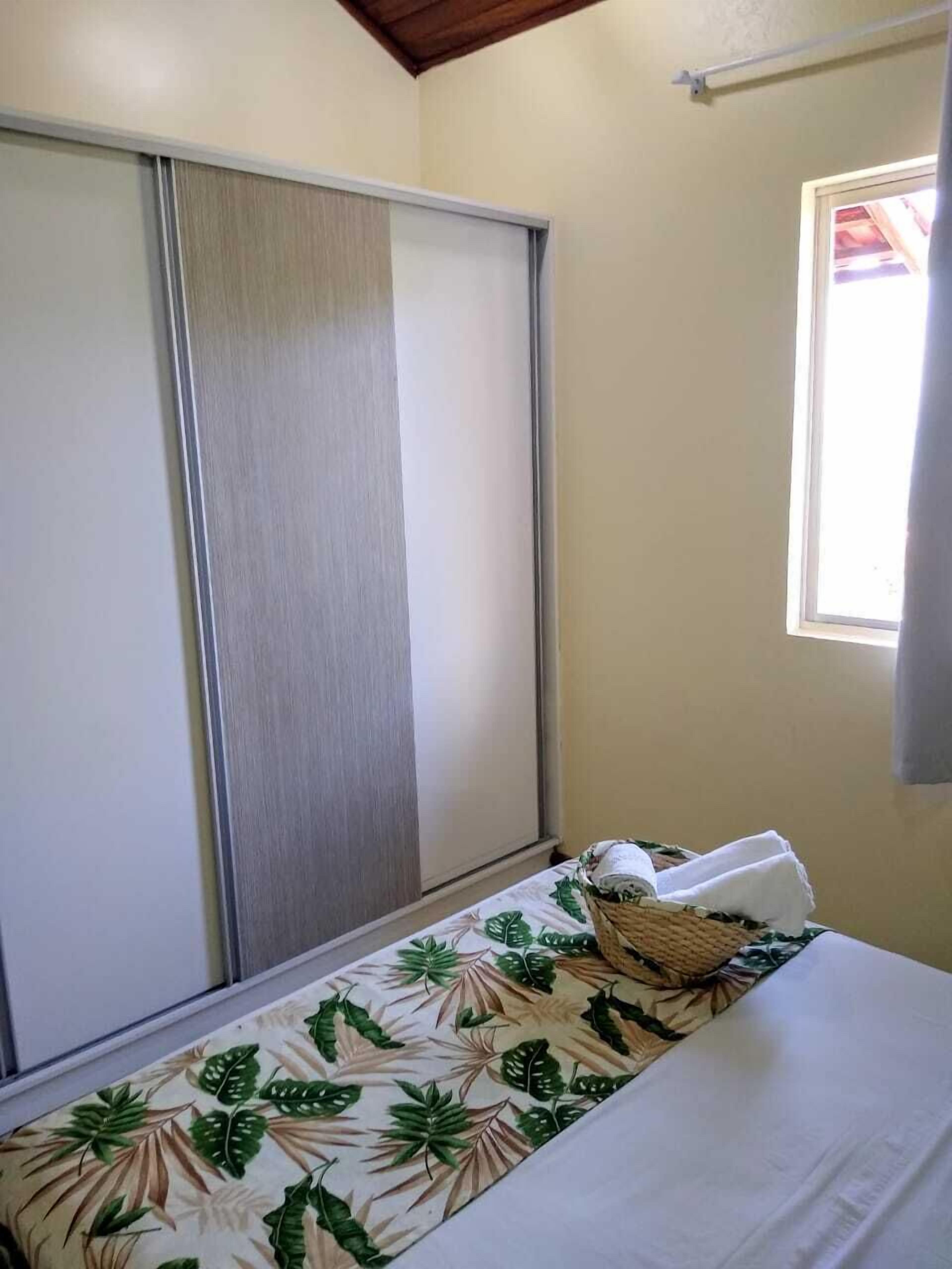 A room with a bed, a sliding door, and a window.