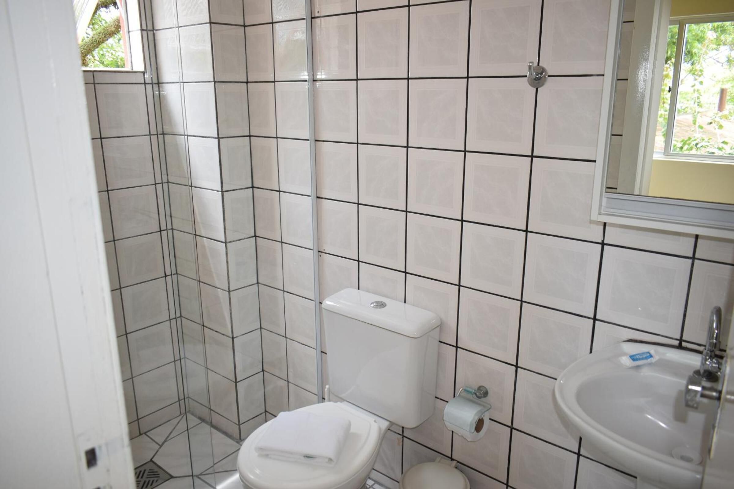 Un baño pequeño con inodoro, lavamanos y paredes de azulejos.