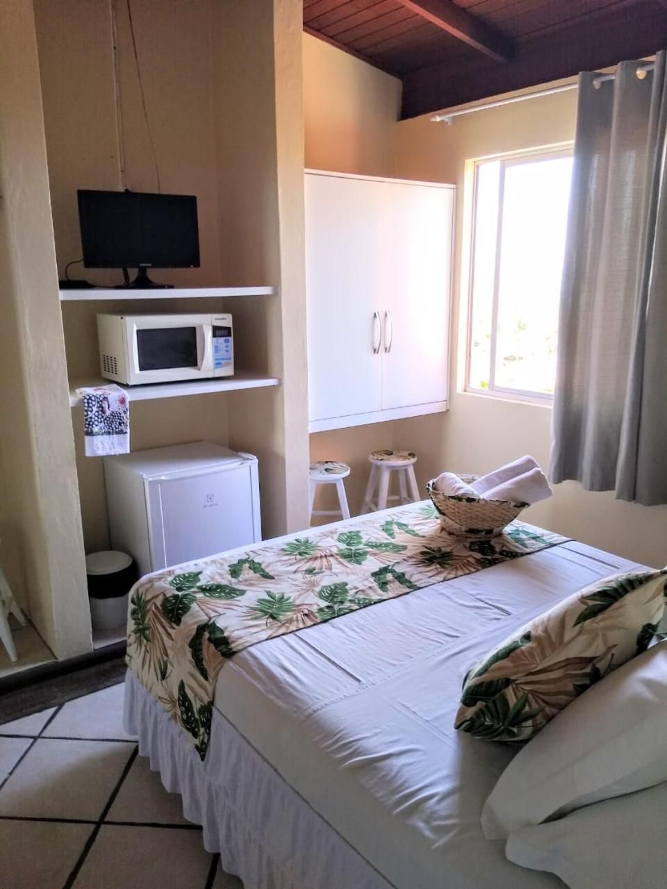 Un dormitorio con cama, televisión, microondas y armario.