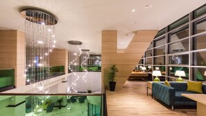 A modern lobby with a glass railing, seating area, and a staircase. - Best Western Premier Batumi (Batumi)