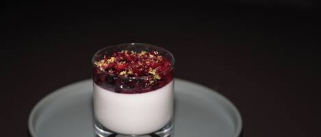 A dessert in a clear glass on a grey plate.