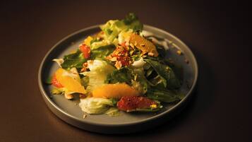 Een bord met salade, diverse groenten en fruit.