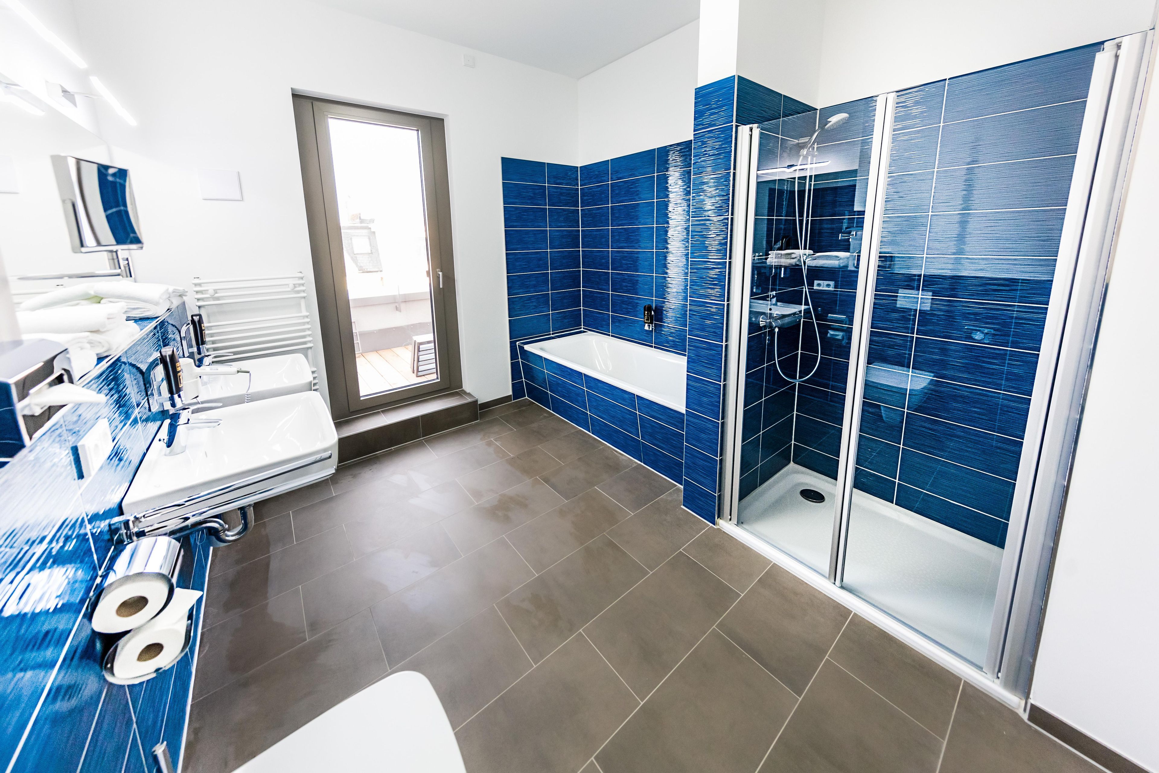 A modern bathroom with a shower, a sink, and a toilet.