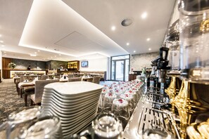 A hotel dining area with tables set for service, a bar area, and a view of the outdoors. - Best Western Plus Royal Suites (Leipzig)