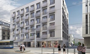 Un edificio moderno de varios pisos con balcones, amplias ventanas y un espacio comercial en la planta baja.