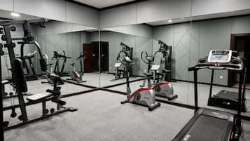 A gym with various exercise equipment including treadmills, stationary bikes, and weight machines.