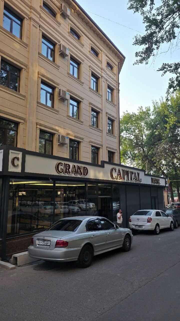 Un hotel con fachada clásica, múltiples ventanas y un letrero destacado.