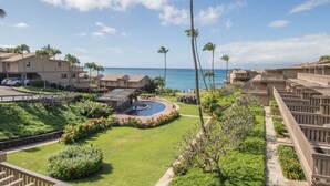 Un resort con piscina, palmeras y vistas al océano.