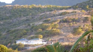 A house on a hillside with a view of a mountain. - Home-styled cottage on Nevis with spectacular views of the Caribbean Sea  (Nevis)