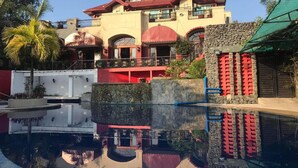 Un edificio de varios pisos con una piscina al frente.
