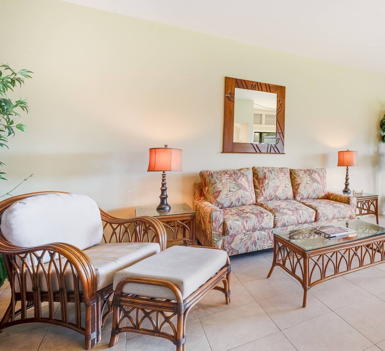 A living room with a sofa, two armchairs, a coffee table, and two lamps.
