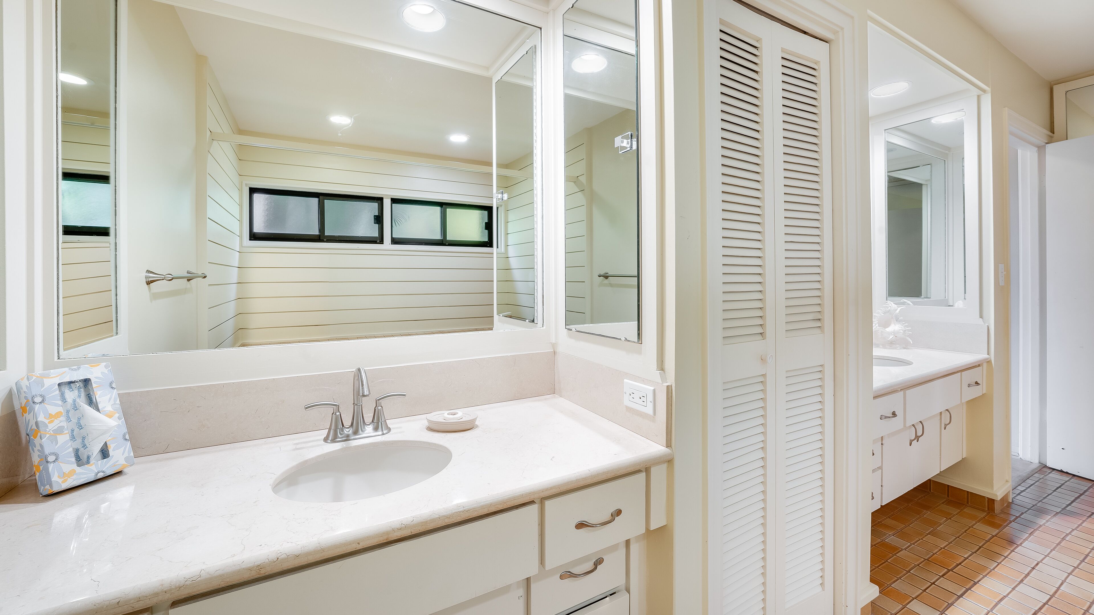 Une salle de bain avec un grand miroir, un lavabo et des toilettes.