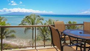 A balcony with a table and chairs overlooking a beach and ocean. - Extended Summer Special $250n 9/1-11/20- 2bd Oceanfront View-SK 344 Sullivan (Lahaina)