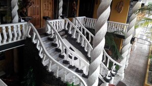 Una escalera de caracol con barandas blancas que conduce a un rellano en el segundo piso.