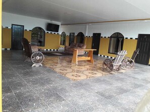 A spacious room with a large wooden table, a wheelchair, and a vintage bicycle. - Hotel Osly del Norte (Canoas)