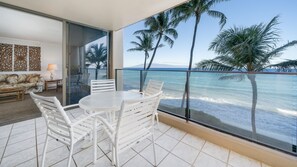 A balcony with a white table and chairs, a sofa, and a decorative wall panel.