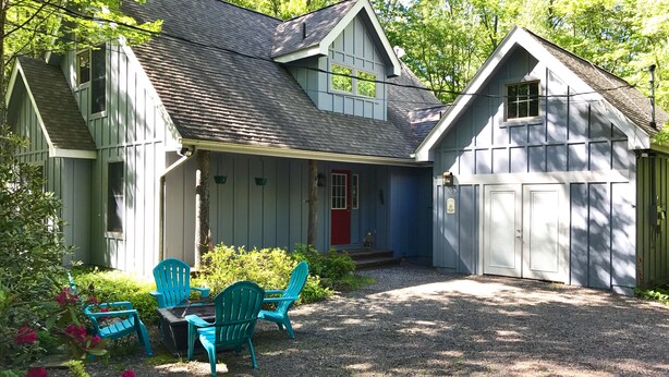 A house with a covered porch, a garage, and a gravel driveway. - ⭐Central heat/AC ⭐ WiFi ⭐ Near pool, lake, beach!⭐ (Pocono Pines)