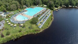 An aerial view of a resort with a large swimming pool surrounded by lounge chairs and a lake. - ⭐Central heat/AC ⭐ WiFi ⭐ Near pool, lake, beach!⭐ (Pocono Pines)