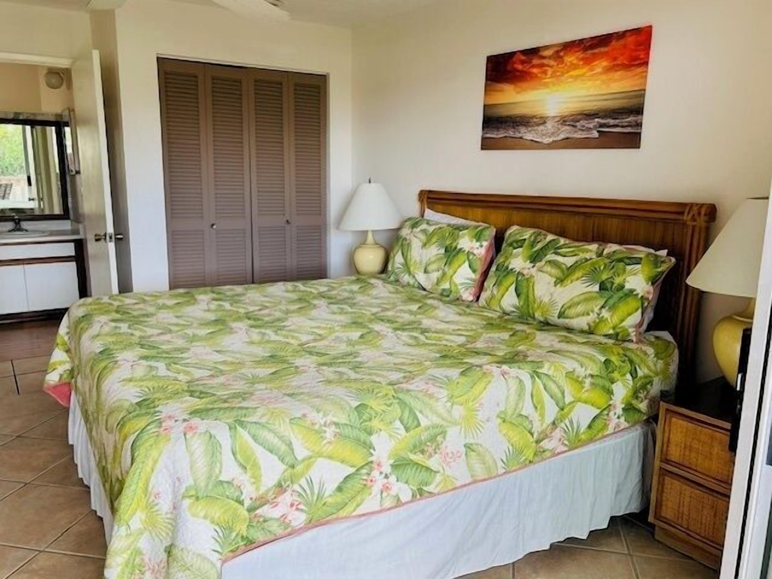 Ein Schlafzimmer mit einem Bett, einem Nachttisch, einer Lampe, einem Gemälde und einem Kleiderschrank.