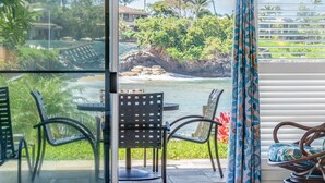 A balcony with a view of the ocean, featuring two chairs and a table. - Remodeled. Ground floor w/ views KSB5B - Sullivan (Lahaina)