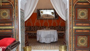 A room with a bed, a table, and two brass bowls. - Traditional riad with modern comfort 6/8 per in the heart of the medina. (Meknès)
