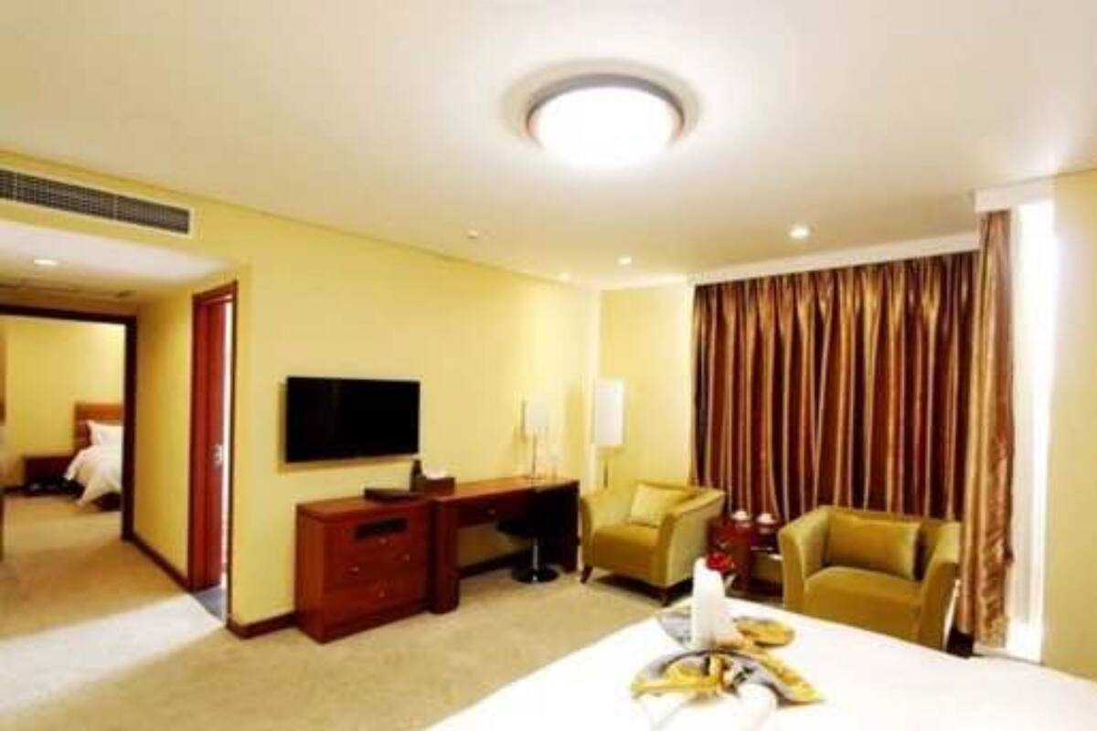 Ein Hotelzimmer mit Bett, Schreibtisch, Fernseher und einer Sitzecke.