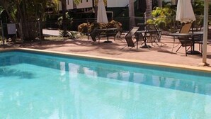 A swimming pool with lounge chairs and umbrellas. - Irish Club Accommodation (Parkside)