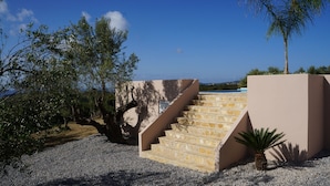 Un escalier menant à un bâtiment d’où l’on a une vue sur la mer.
