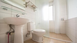 A bathroom with a white sink, toilet, and shower area. - Dog House (Taitung)