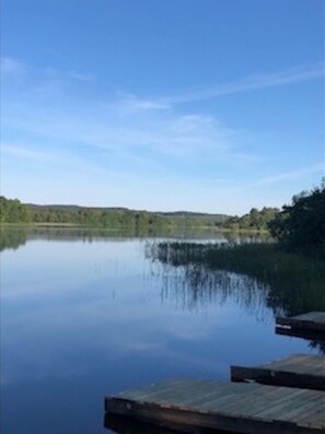 Tyyni järvi, jonka rannalla on puinen laituri, joka ulottuu veden päälle.