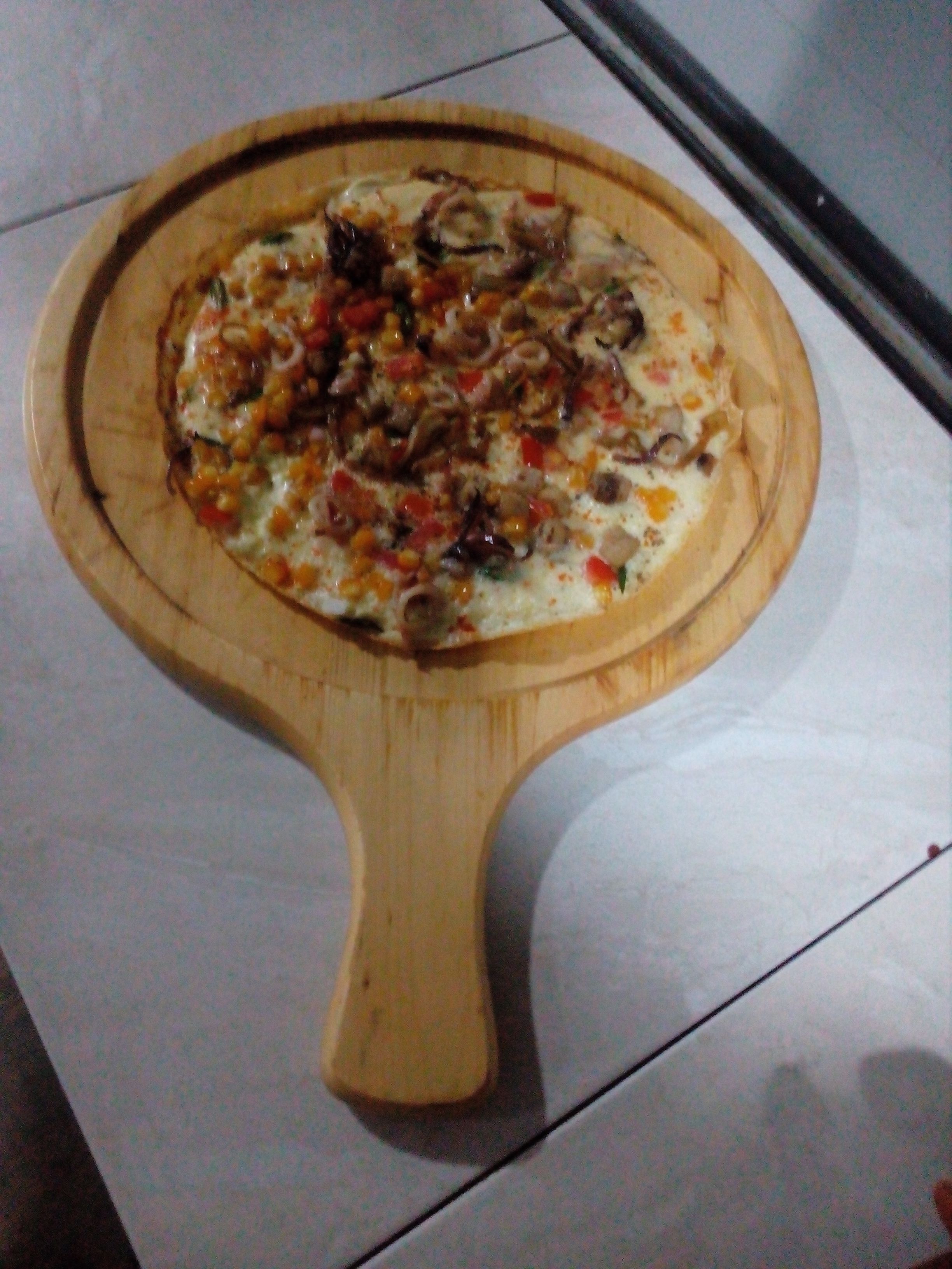 Una pizza sobre una tabla de madera.