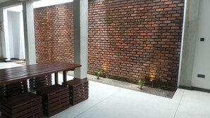 Un interior moderno con pared de ladrillo, una mesa de madera y bancos.